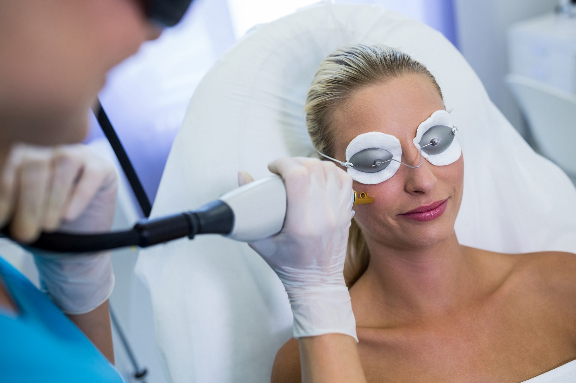 Patient receiving a facial laser treatment while wearing protective eyewear